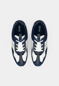 Αθλητικά παπούτσια σε ναυτικό μπλε και λευκό με διάτρητο σχέδιο, υφασμάτινη υφή, λαστιχένιες σόλες και αντίθετες λεπτομέρειες. Διαθέτουν λευκά κορδόνια και λογότυπο.