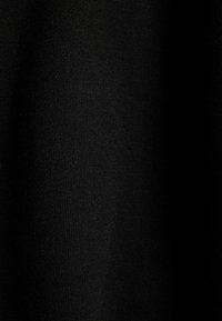 Tessuto nero con una texture liscia, che presenta un motivo a maglia fine. Il materiale sembra morbido e leggero, senza motivi o accenti visibili.