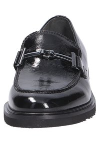 Schwarze Lackleder Slipper mit runder Spitze, die ein dekoratives Metall-Element an der Vorderseite und eine strukturierte schwarze Gummisohle aufweisen.