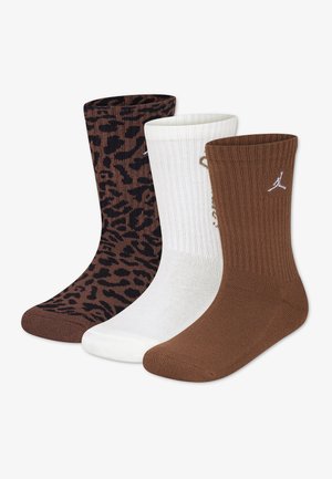 Tres pares de calcetines hasta media pantorrilla en estampado de leopardo marrón, blanco liso y marrón sólido con un pequeño logo blanco cerca de la parte superior.