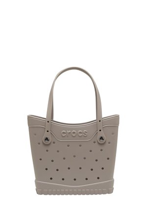 Light gray tote bag made of rubber-like material; features a perforated design, dual handles, and embossed "crocs" logo on the side.
