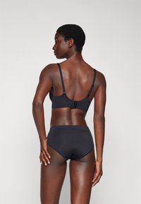 Black bra and high-waisted brief set, made from smooth fabric, featuring adjustable straps and a hook-and-eye closure at the back.