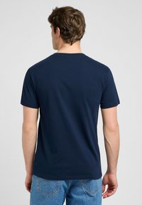Granatowa koszulka z krótkim rękawem wykonana z bawełny z okrągłym dekoltem. Gładka tekstura, bez widocznych wzorów czy grafiki. Prosty, dopasowany krój.