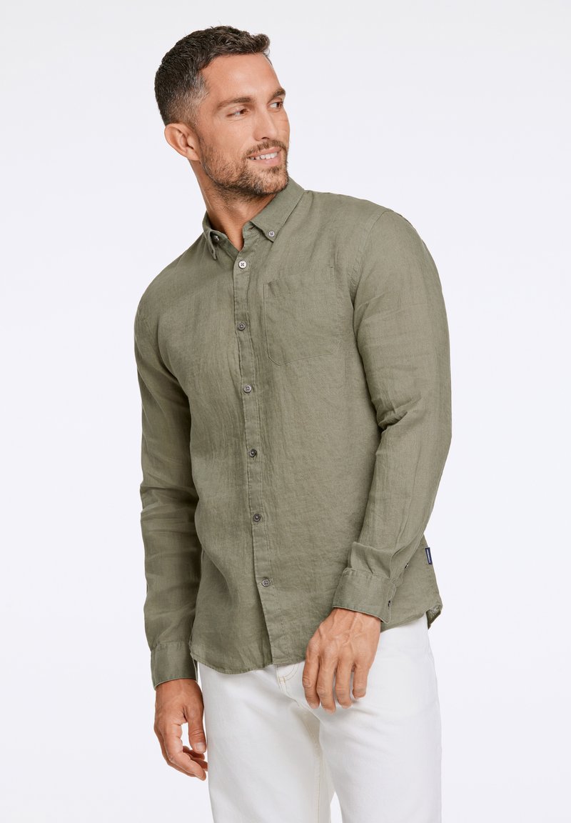 Camisa de manga larga verde olivo hecha de una tela texturizada, con cuello abotonado, bolsillo frontal y botones marrones.