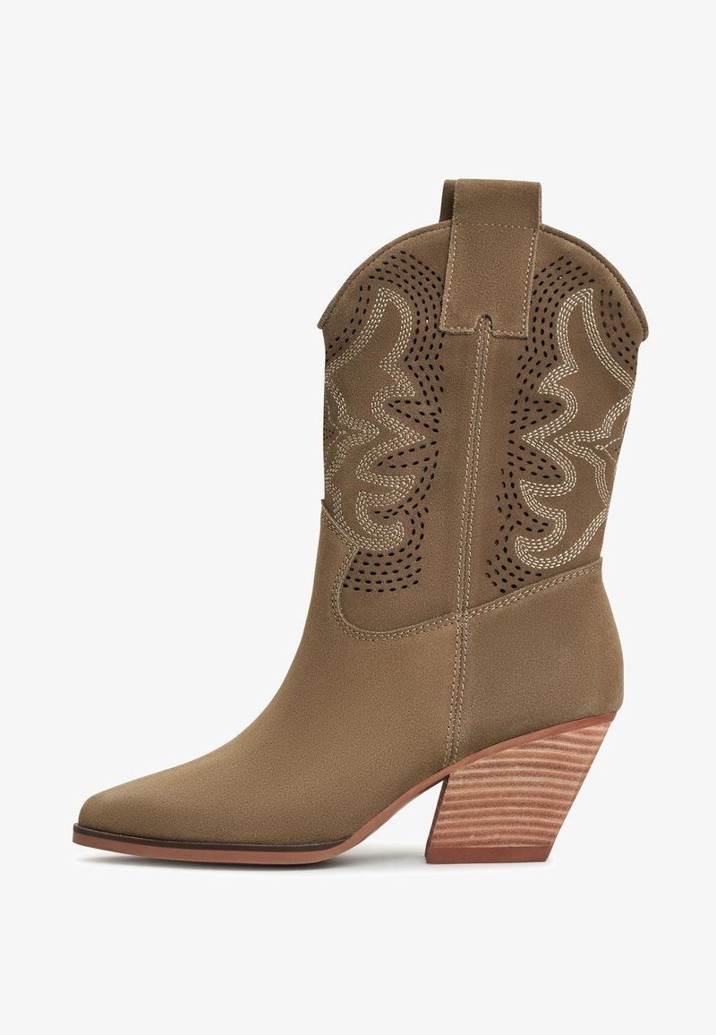 Botă de cowboy din suede maro, cu vârf ascuțit, decorațiuni tăiate și accente cusute. Dispune de un toc din lemn stratificat pentru un plus de înălțime.