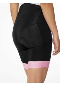 Pantaloni da ciclismo neri con un tessuto testurizzato, dotati di un'orlo elastico rosa alle aperture delle gambe e di un'area imbottita per il comfort.