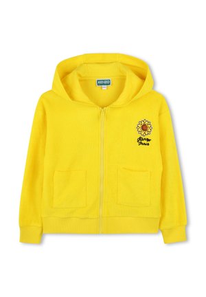 Haut à zip jaune en tissu éponge doux, mettant en avant un motif de tournesol à l'avant et deux poches à l'avant. Manches et ourlet côtelés.
