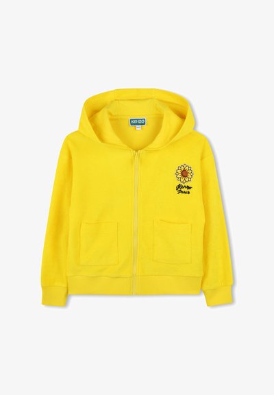 Gele ritssluiting hoodie van zacht terry stof, met een afbeelding van een zonnebloem aan de voorkant en twee voorzakken. Geribde manchetten en zoom.