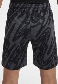 Shorts à motifs noirs et gris avec une taille élastique et un tissu léger et texturé. Présente des designs abstraits dynamiques.