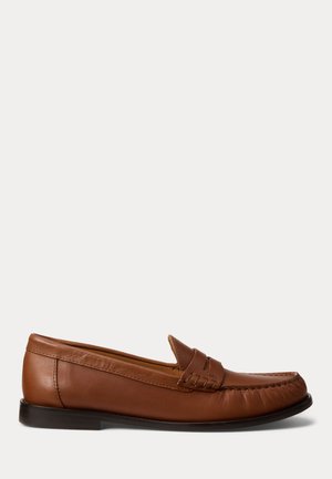 Ruskea nahkainen loafer-mallinen kenkä, jossa matala musta korko, mokkapääommel ja koristeellinen remmi päällä, esitetty valkoista taustaa vasten.