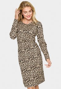 Haljina s leopard uzorkom, dugih rukava, uskog kroja, izrađena od mekog materijala, s bež pozadinom i crnim i smeškim mrljama.