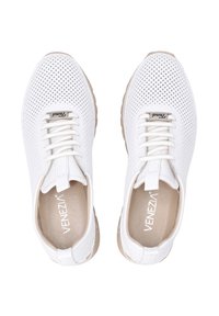 Hvide perforerede sneakers med beige gummisåler, udstyret med hvide snørebånd og logo-accenter på tungen og indersålen.