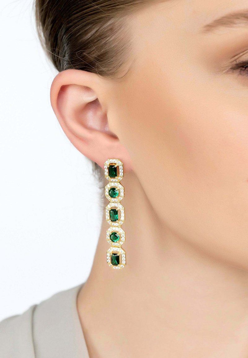 Gold drop earrings with five emerald-cut green gemstones, each framed with clear, sparkling accents, hanging elegantly from the earlobe.