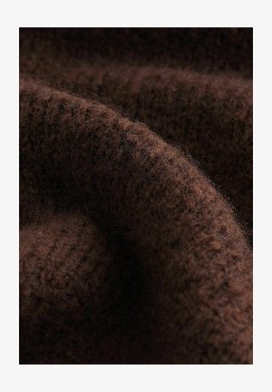 Tissu tricoté marron avec une texture douce et duveteuse et des variations subtiles de ton, mettant en valeur les motifs de points complexes et la chaleur.