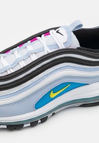 Tenisky Nike Air Max 97 s vícerozměrným designem v světle modré, černé a bílé barvě s růžovými akcenty a žlutým logem.