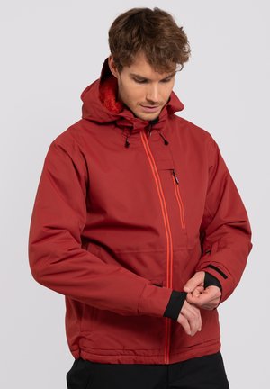 Chaqueta impermeable roja con capucha, que cuenta con un brillante zipper naranja, puños negros y un bolsillo en el pecho. Cuello forrado de forro polar para mayor calidez.