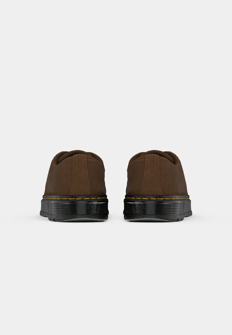 Chaussures en daim marron avec profil bas, semelle en caoutchouc noir, couture jaune et design à bout rond. La vue arrière montre une texture lisse et une finition sans couture.