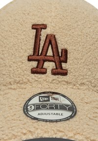 Beige fleece muts met een geborduurd "LA" logo in bruin. Inclusief een rond New Era logo label met "9FORTY ADJUSTABLE."