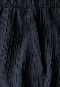 Mörk marinblå veckad tyg med en texturerad yta, med vertikala linjer och en elastisk midja som säkerställer en bekväm passform.