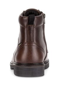 Bottine en cuir marron avec semelle en caoutchouc noir, fermeture éclair sur le côté et tirant. Possède une finition lisse et des détails de couture subtils.