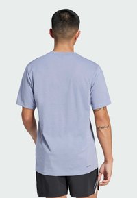 Svetlo modré bavlnené tričko s krátkymi rukávmi a okrúhlym výstrihom, s logom na leme a hladkou textúrou.