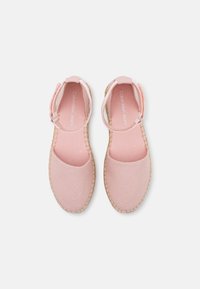 Lichtroze canvas espadrilles met een ronde neus, enkelbandje en een geweven jute zool, met een zachte textuur en een minimalistisch ontwerp.