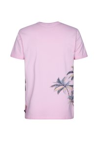 Camiseta de algodón rosa con un vibrante estampado de palmera en el lado izquierdo, mangas cortas y cuello redondo. Espalda lisa.
