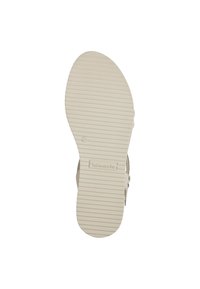 Suola di sandalo beige con linee verticali testurizzate e marchio. Superficie liscia, forma leggermente curva e design della punta arrotondata.
