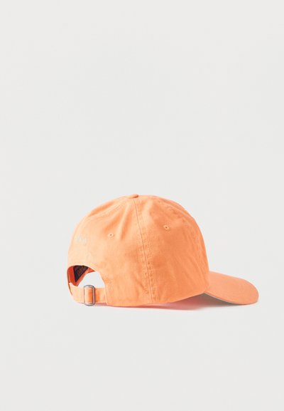 Πορτοκαλί καπέλο μπέιζμπολ που βρίσκεται στο πλάι, εμφανίζοντας το ρυθμιζόμενο λουράκι με μεταλλική αγκράφα στο πίσω μέρος, σε ένα απλό ανοιχτό φόντο.