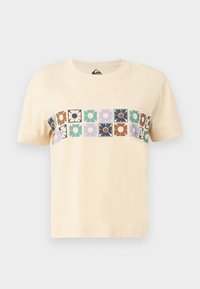 Crème-kleurige katoenen t-shirt met een horizontaal blokpatroon van gestileerde bloemen in verschillende kleuren. Korte mouwen en ronde hals.