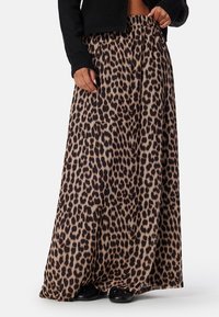 Maxi sukně s leopardím potiskem vyrobená z měkké tkaniny, s elastickým pasem a splývavým designem, v béžových a tmavě hnědých odstínech.