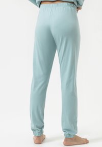 Lichtblauwe katoenen joggers met elastische tailleband en boorden, met een gladde textuur en taps toelopend ontwerp. Geen zichtbare patronen of hardware.