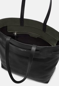 Czarna skórzana torba tote o gładkiej fakturze, z dwiema czarnymi uchwytami, ciemnozielonym wnętrzem oraz zamkniętą na zamek kieszenią.