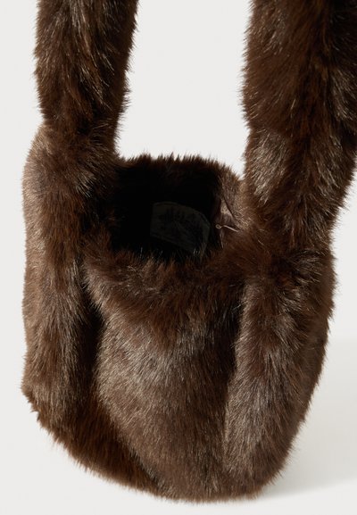 Sac à main en fausse fourrure marron au toucher doux, de forme ronde et avec de solides doubles anses. Intérieur doublé d'un tissu lisse avec une étiquette visible.