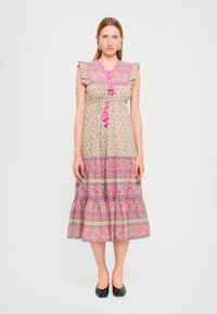 Lys grønn bomulls maxi-kjole med rosa blomster mønster, volang ermer, og tre rosa dusker ved halsen. Utsvingt fald.