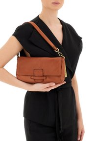 Borsa a tracolla in pelle marrone con chiusura a pattina, hardware dorato e tracolla removibile. Texture liscia e forma rettangolare.