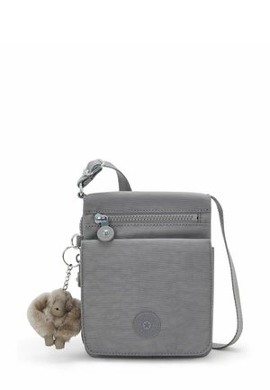 Gray crossbody bag made of soft fabric with a zippered pocket, logo patch, and a plush charm keychain. Adjustable strap.