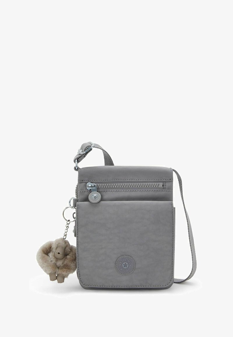 Bolso cruzado gris hecho de tela suave con un bolsillo con cremallera, parche de logo y un llavero de charm de peluche. Correa ajustable.
