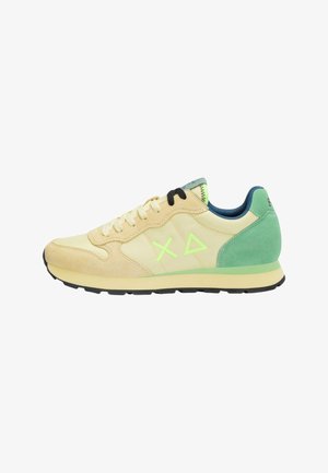 Sneaker beige e verde chiaro con accenti in camoscio, suola esterna nera, logo verde neon e fodera interna blu scuro, mostrata di profilo.