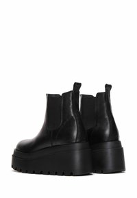 Black leather platform boots with a chunky sole, elastic side panels, and pull tabs at the back for easy wear. Smooth texture with minimal accents.