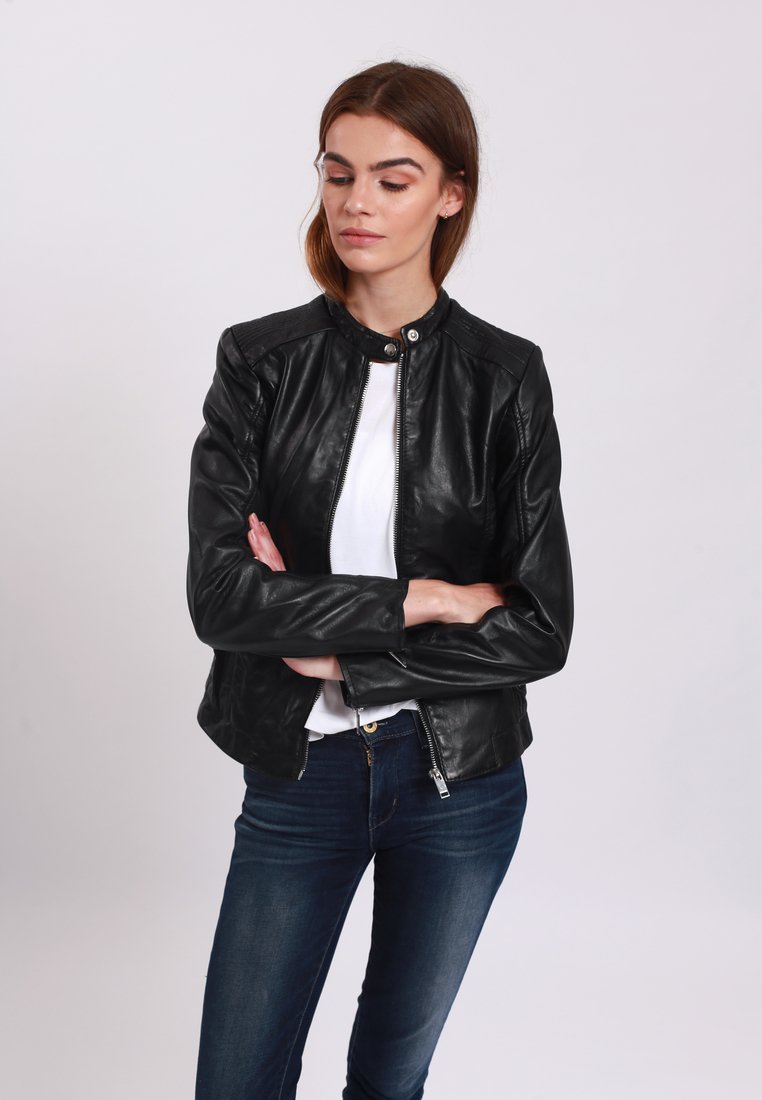 Black leather jacket with a snap collar, zip front, and fitted design. Features smooth texture and shoulder accents. Worn over a white shirt.