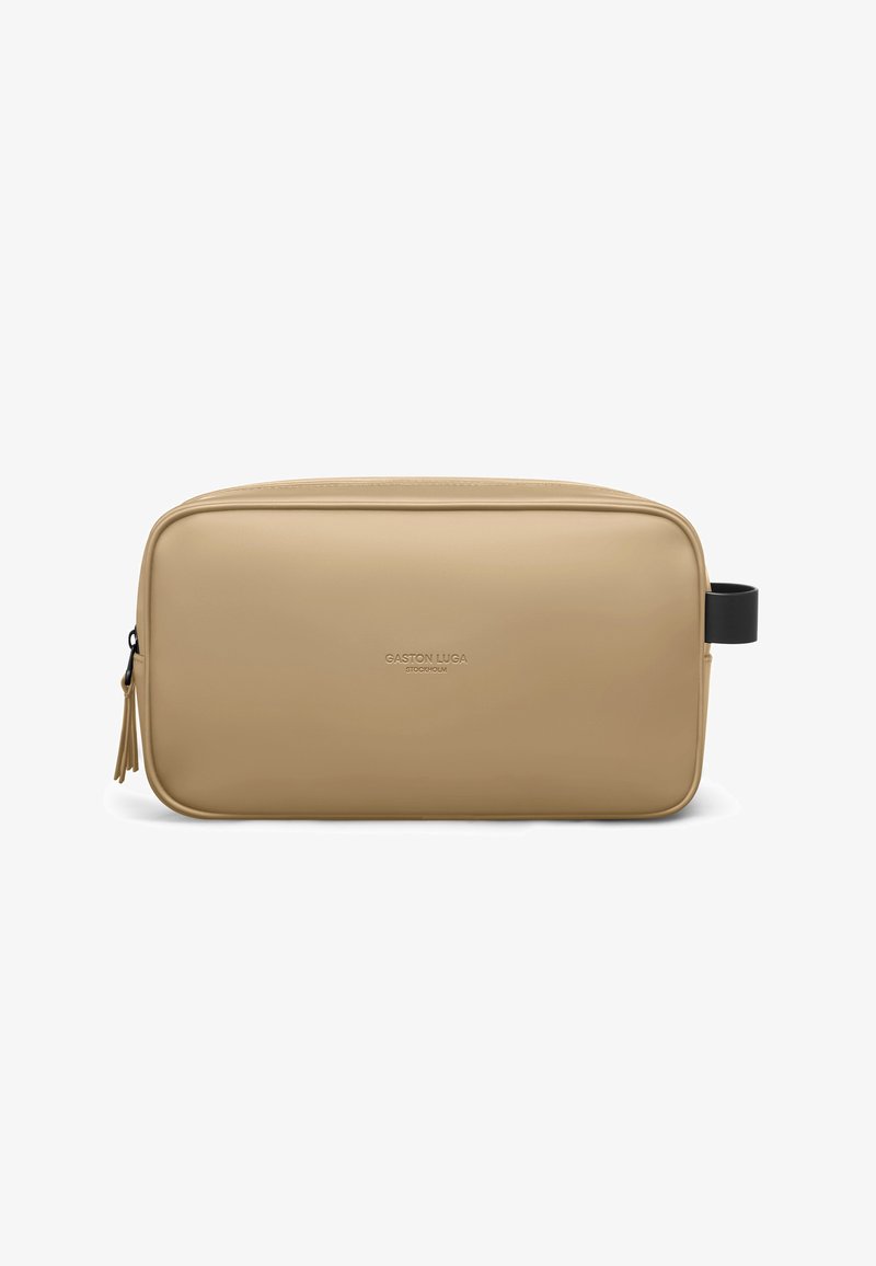Trousse de toilette rectangulaire en toile beige avec fermeture éclair, poignée latérale noire et inscription "Gaston Luga Stockholm" embossée au centre avant.