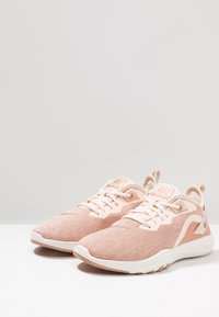 Lichtroze sportschoenen met een textuur van mesh bovenwerk, versterkte veterogen, een witte zool en subtiele designelementen.