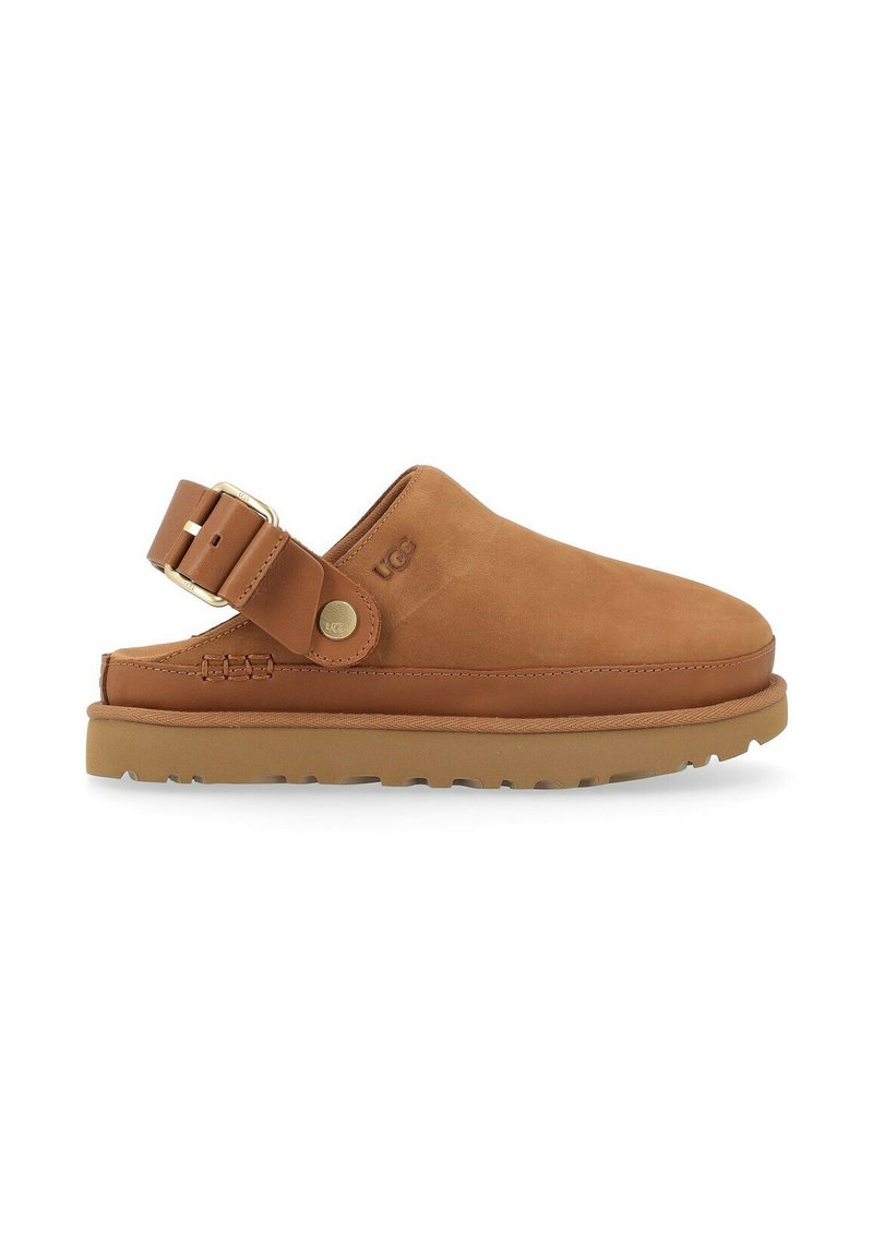 Zuecos de cuero marrón con tira trasera, punta redonda y suela texturizada. Acento de hebilla ajustable en la tira y detalle del logo de UGG.
