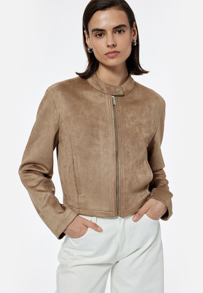 Helle Wildlederjacke mit cropped Design, Stehkragen und Frontreißverschluss. Verfügt über seitliche Taschen und eine glatte Textur.