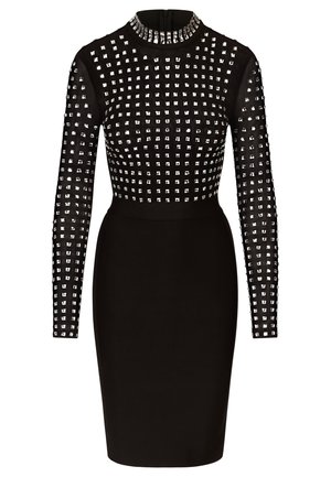 Schwarzes, eng anliegendes Kleid mit langen Ärmeln, das oben ein Gitter von silbernen Nieten und einen glatten Rock aufweist. Hoher Kragen und Reißverschlussdetail am Rücken.