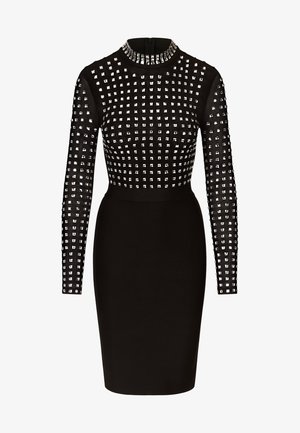 Black fitted dress with long sleeves, featuring a grid of silver studs on the top and a smooth skirt. High collar and back zipper detail.