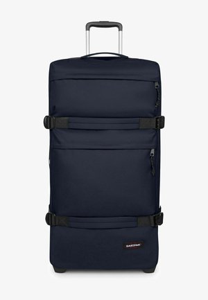 Marineblauer Trolley mit ausziehbarem Griff, zwei schwarzen Kompressionsriemen, vorderen Reißverschlusstaschen und Eastpak-Logo unten rechts.