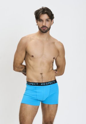 Shorts en coton bleu avec une taille noir portant le texte "RESPECT." Le design est ajusté, avec une texture lisse et sans motifs.