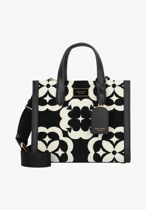 Czarna i biała torebka Kate Spade w kwiatowy wzór, z czarnymi skórzanymi uchwytami, odpinanym paskiem na ramię oraz przypinką z logo na przedzie.